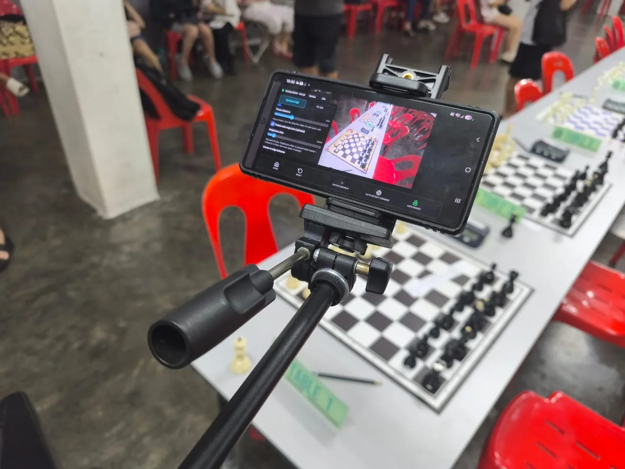 ChessZCam phone controller beside a physical chessboard at Keong Hoe