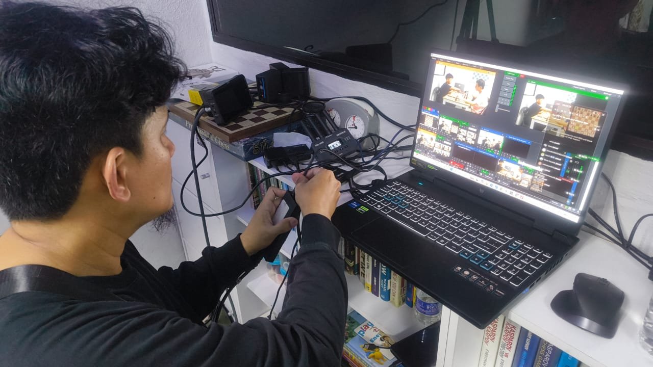 A phone on a tripod recording a real tournament board
