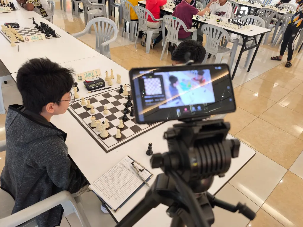 Actual phone and tripod setup recording a featured chess board at a tournament